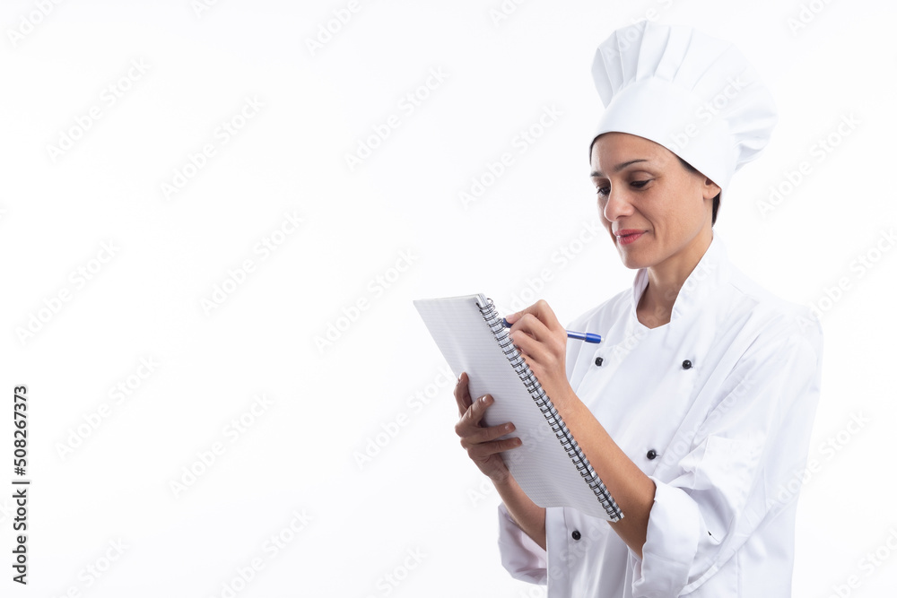 Woman chef writing in her notebook isolated on white background with copy space. Woman chef writing in her notebook isolated on white background with copy space.