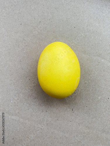 Yellow egg. Decoration for Easter. Traditional holiday food. Colored egg. Close front view.