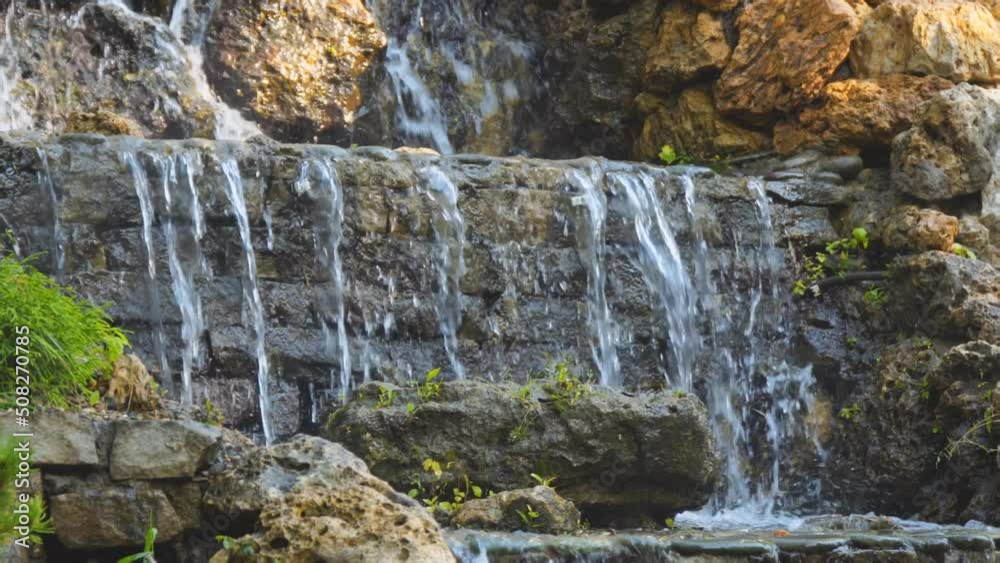A small artificial waterfall in the park. Selective focus. Soft focus A small artificial waterfall in the park. Selective focus. Soft focus