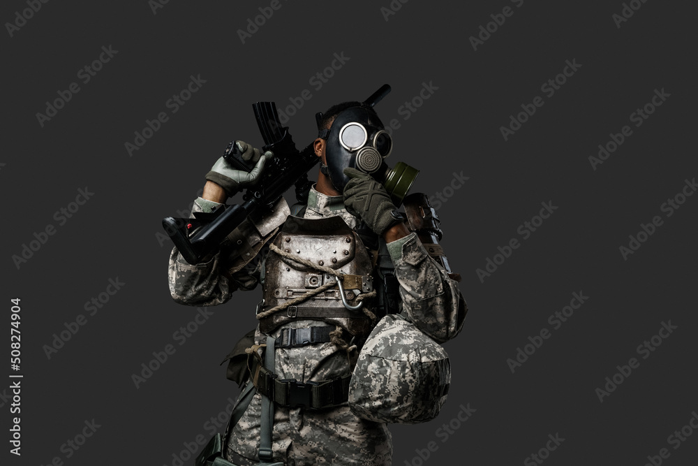 Studio shot of black army soldier dressed in protective gas mask and camouflage clothes.