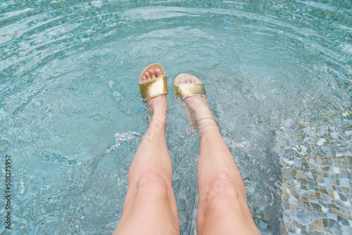 Women's feet in flip-flops in the pool. photo