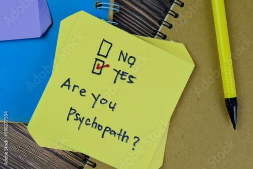 Concept of Are you Psychopath? Yes write on sticky notes isolated on Wooden Table. photo