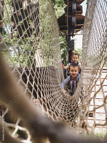Joyful children in a net in a rope park