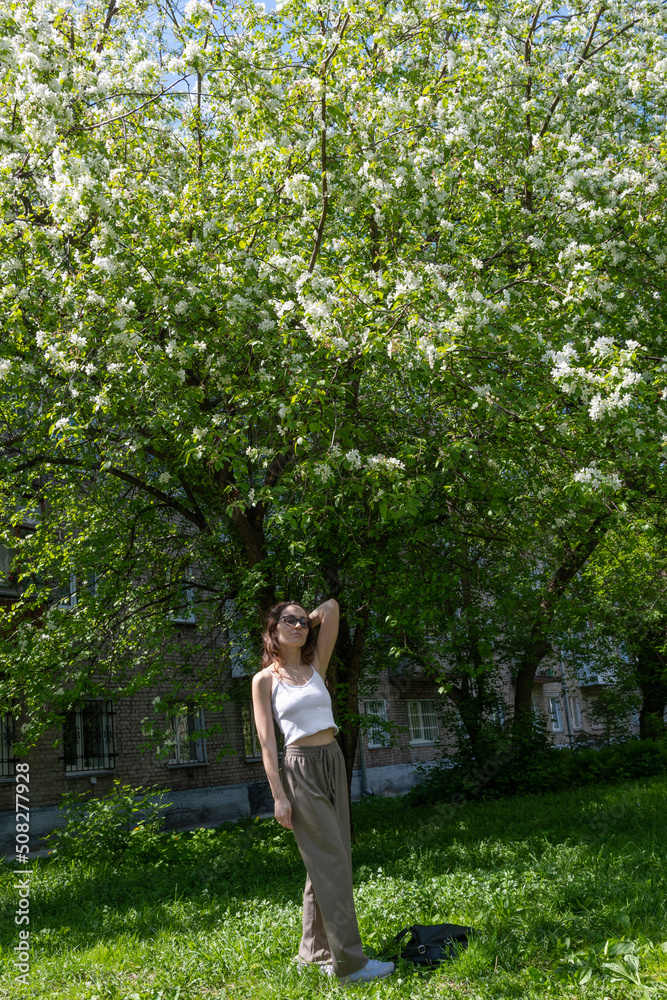 Spring fashion girl outdoor portrait in blooming trees. Beauty Romantic woman in flowers. Sensual Lady. Beautiful Woman Enjoying Nature. Romantic beauty in fantasy orchard Spring fashion girl outdoor portrait in blooming trees. Beauty Romantic woman in flowers. Sensual Lady. Beautiful Woman Enjoying Nature. Romantic beauty in fantasy orchard
