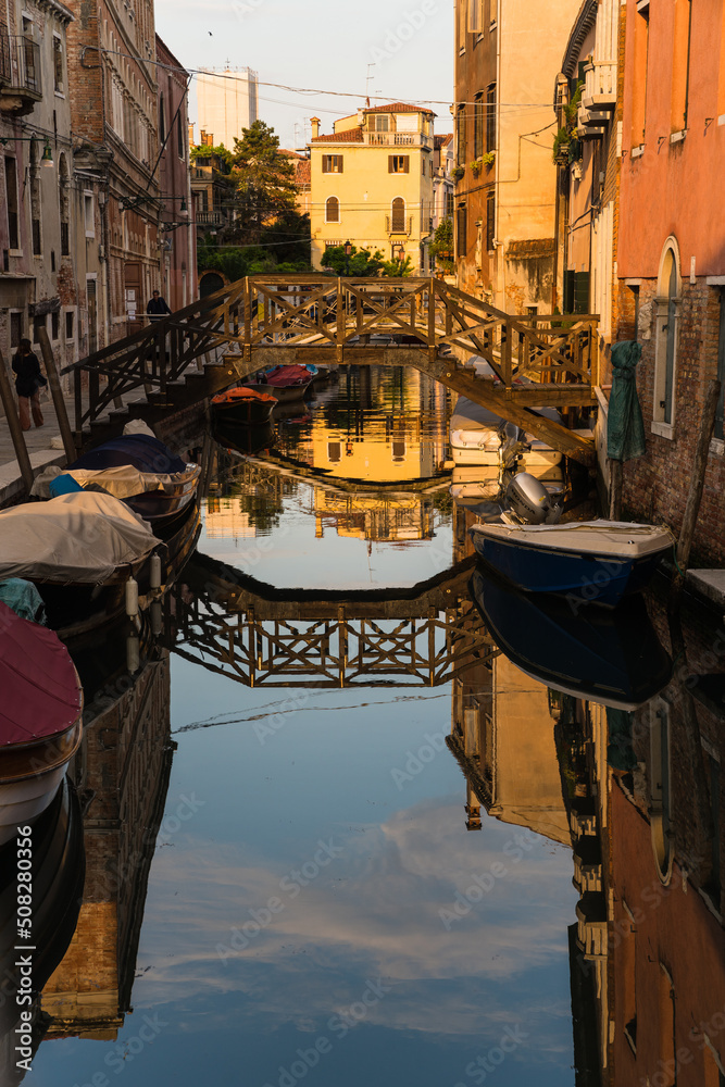 bridge over a canal and reflection on the water in Venice, Italy 