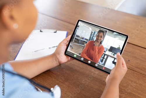 African american female doctor and patient talking on video call over digital tablet