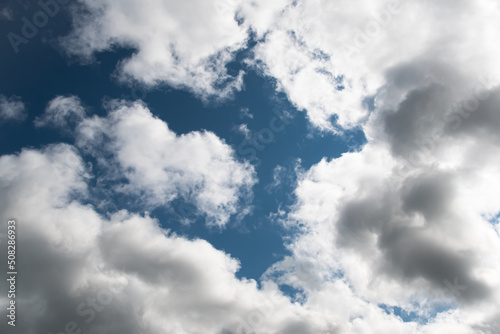 Blue sky with puffy clouds for background. Atmospheric phenomena in formation of precipitation.