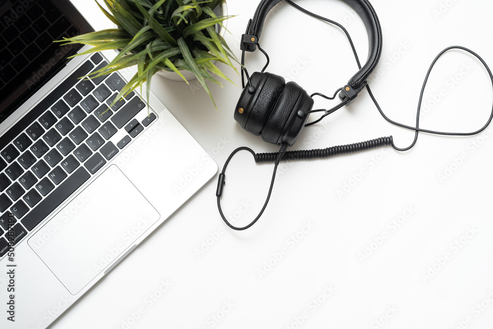 Laptop and headphones on a white background with copy space. Office concept. Flat lay, top view Laptop and headphones on a white background with copy space. Office concept. Flat lay, top view