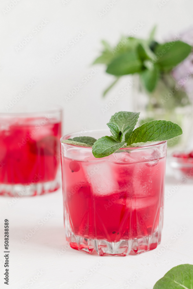 Cranberry drink with ice and mint on a white background. Cranberry drink with ice and mint on a white background.