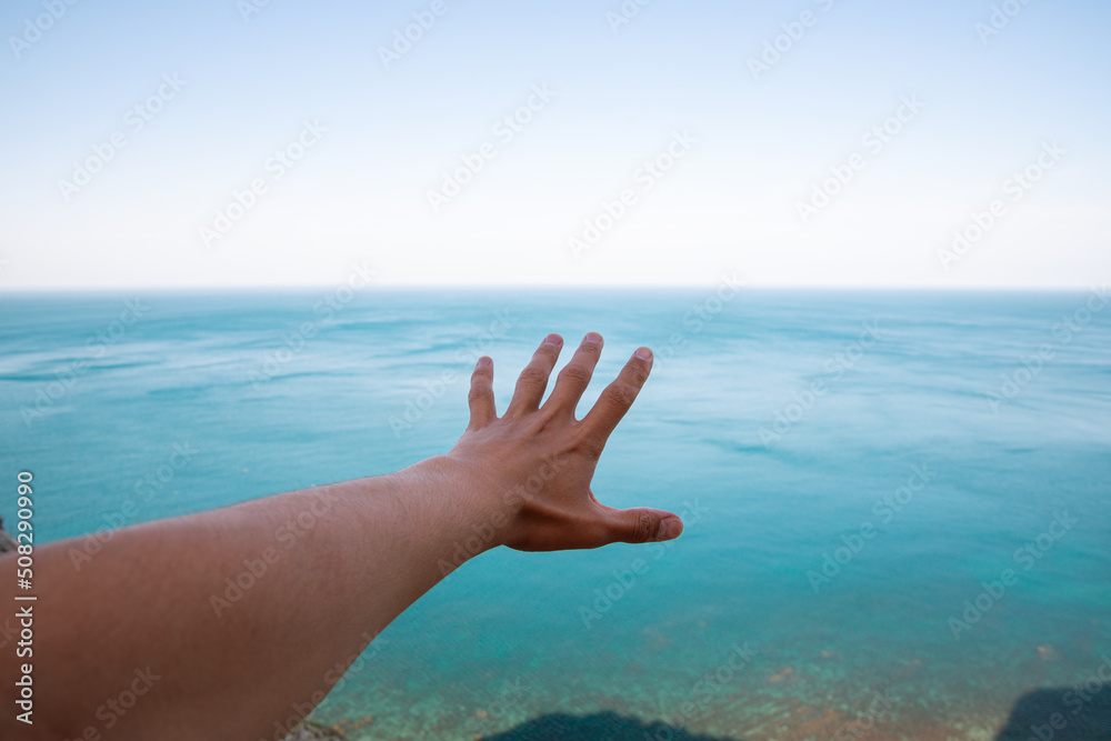 Man's hand on the background of mountains near the sea. Man's hand on the background of mountains near the sea.