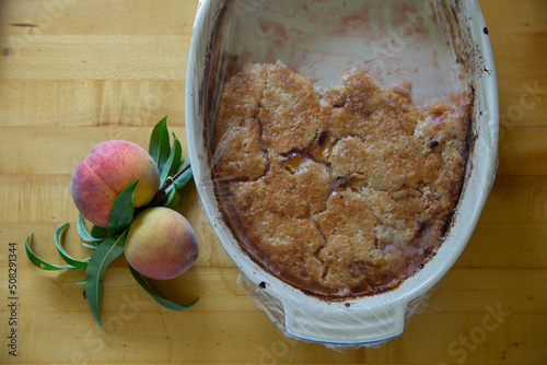 peach cobbler on table with peaches 2 photo