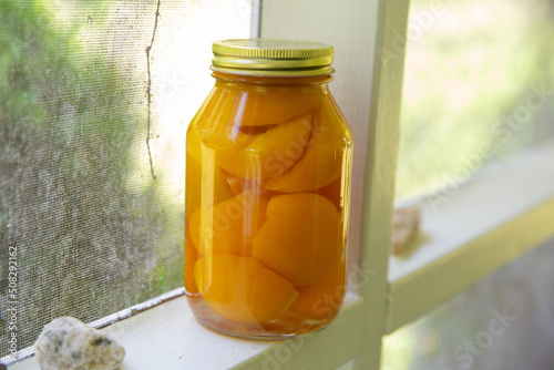 jar of pickled peaches on porch photo