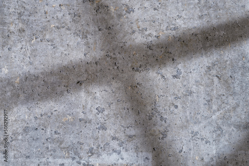 Rough concrete wall with the crossed shadows close up