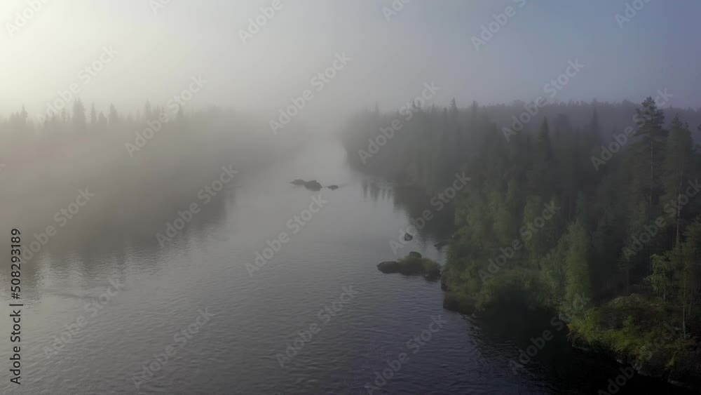 Flight above covered with fog forest river. Tuntsayoky river, Murmansk Oblast, Russia. Flight above covered with fog forest river. Tuntsayoky river, Murmansk Oblast, Russia.