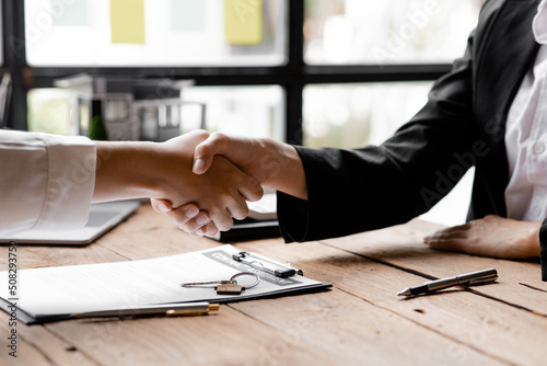 The salesperson of the housing estate in the project and the customer shake hands after successfully signing the contract. Concept of selling housing estates and real estate.