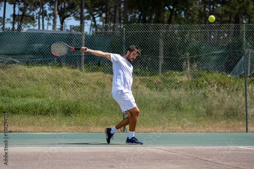 Quadro em tela Tennis player hitting backhand at ball