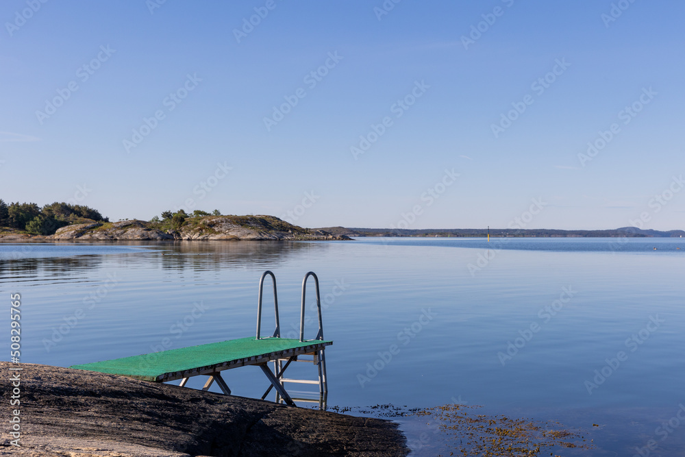 Bridge and swimming ladder with calm sea and sea weed and rocky islands. Bridge and swimming ladder with calm sea and sea weed and rocky islands.