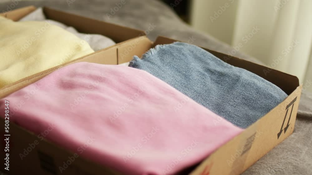 Stack clothing for sorting and donation in cardboard boxes. Clothes for charity. Folding clothing storage and environmentally friendly consumption. Stack clothing for sorting and donation in cardboard boxes. Clothes for charity. Folding clothing storage and environmentally friendly consumption.