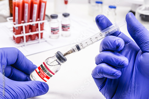 pharmacist's hand with latex glove preparing monkeypox vaccine, pharmaceutical laboratory photo