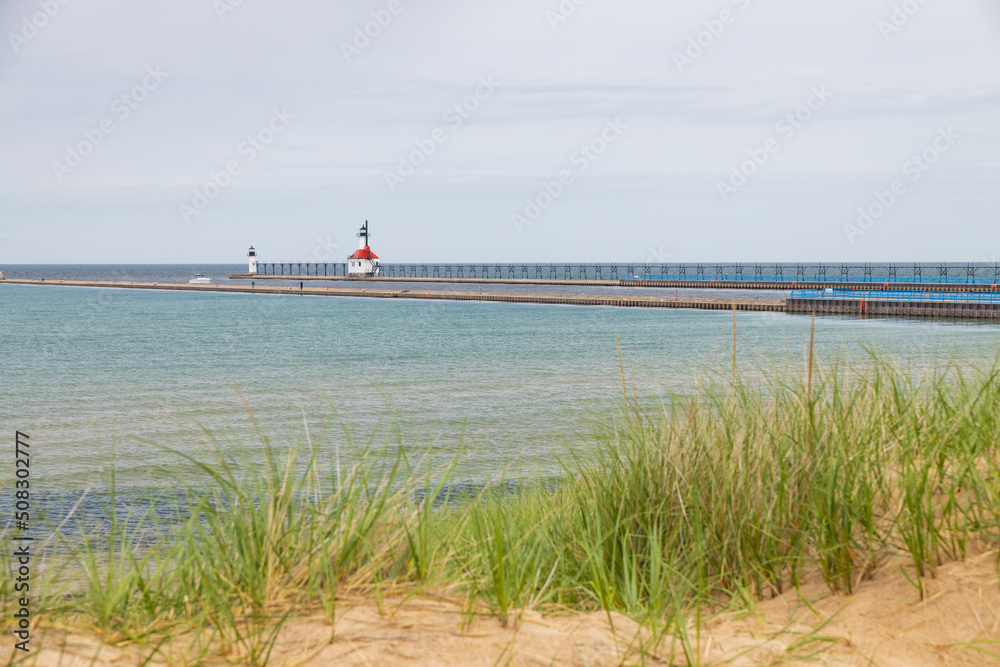 Sand beach and beachgrass with St. Joseph North Pier Inner Lighthouse and St. Joseph North Pierhead Outer Lighthouse, Michigan in background
