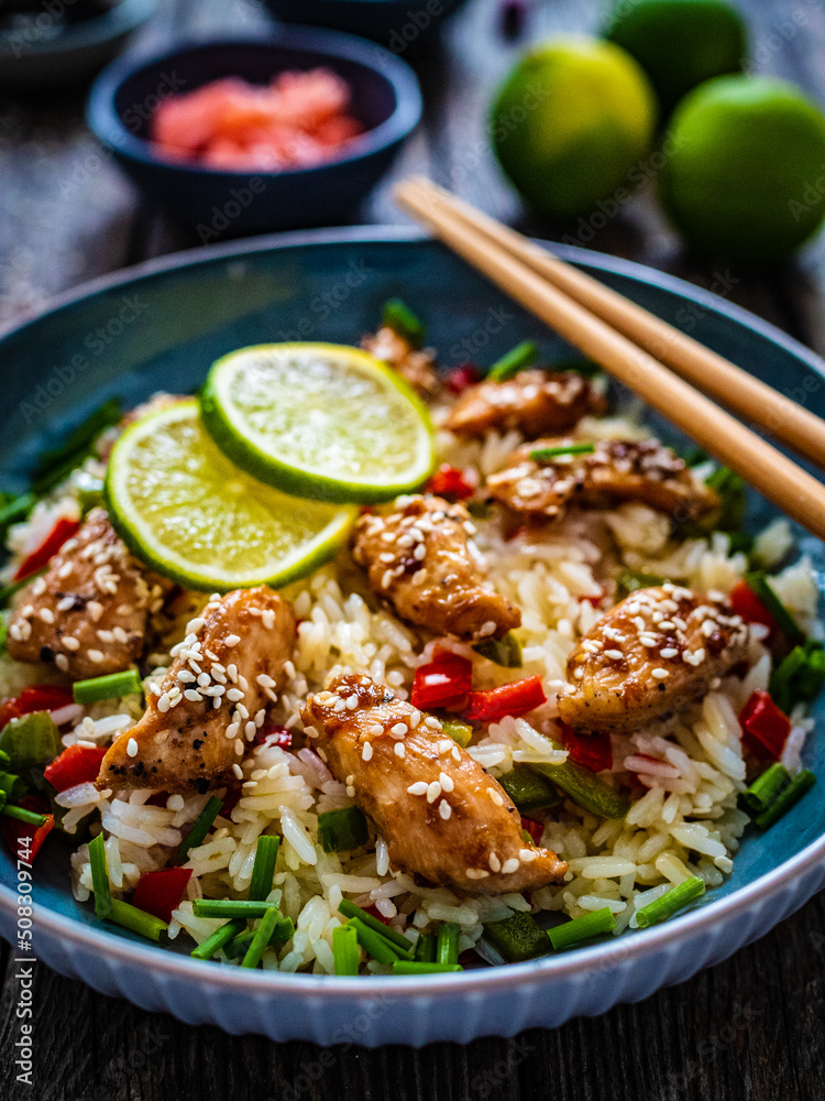 Teriyaki chicken nuggets with rice and vegetables on wooden table
