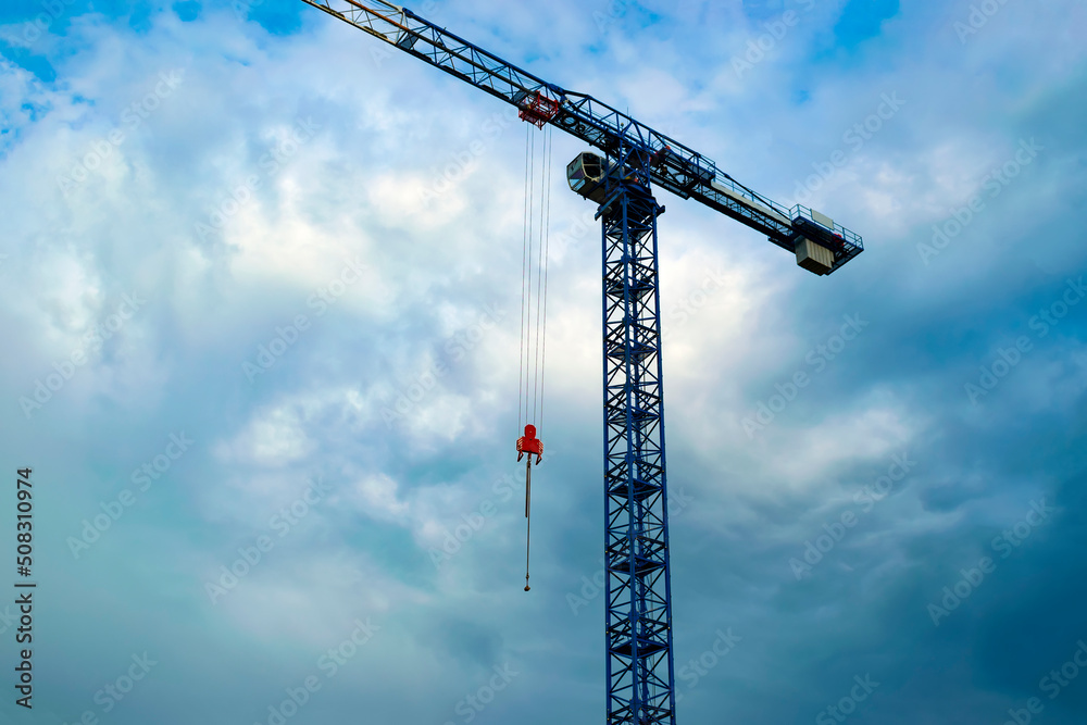lifting construction tower crane on the background of thunderclouds in a cloudy sky. dramatic clouds lifting construction tower crane on the background of thunderclouds in a cloudy sky. dramatic clouds