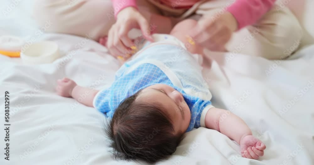 Mother changing baby diaper Mother changing baby diaper