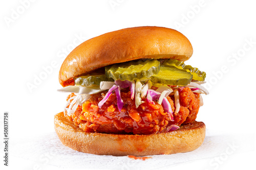 Spicy country fried chicken sandwich on a brioche bun with pickles and coleslaw; white background; copy space