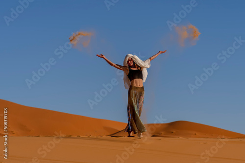 A Beautiful Model Poses In The Sand Dunes In The Great Sahara Desert In Morocco, Africa