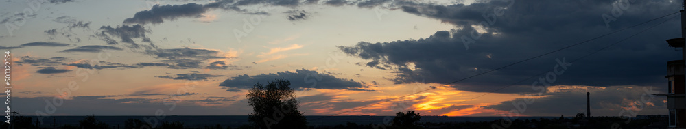 Landscape at sunset. Tragic gloomy sky. The village in the Budjak steppe. Panorama. Crimson twilight.