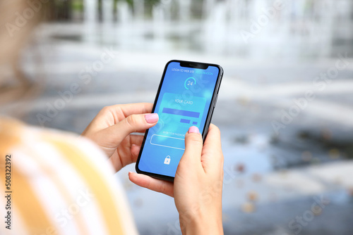 Young woman using modern smartphone for online payment photo