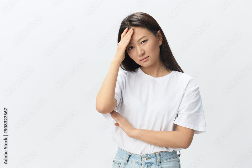 Migraine. Side view of unhappy suffering from headache tanned beautiful young Asian woman touching forehead posing isolated on white background. Injuries Poor health Illness concept. Cool offer Banner Migraine. Side view of unhappy suffering from headache tanned beautiful young Asian woman touching forehead posing isolated on white background. Injuries Poor health Illness concept. Cool offer Banner