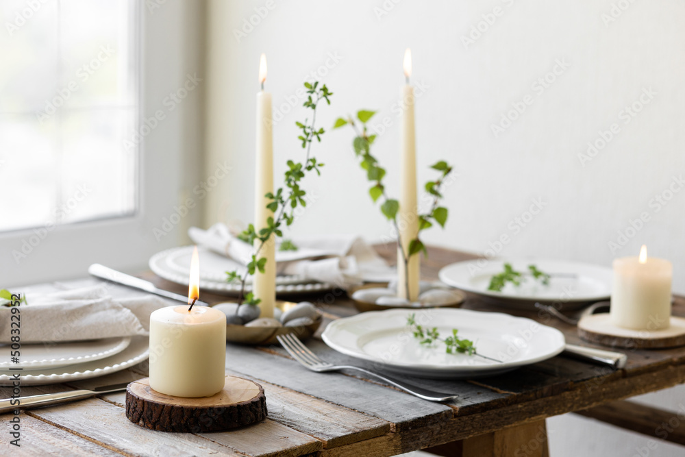 Rustic zero waste wedding decor with natural elements. Wooden table, candles, linen napkins, branches with green leaves. Eco-friendly decoration for the special dinner. Romantic and cozy place Rustic zero waste wedding decor with natural elements. Wooden table, candles, linen napkins, branches with green leaves. Eco-friendly decoration for the special dinner. Romantic and cozy place