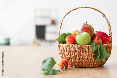 Fototapeta Naklejka Na Ścianę i Meble -  Wicker basket with different fruits on wooden table