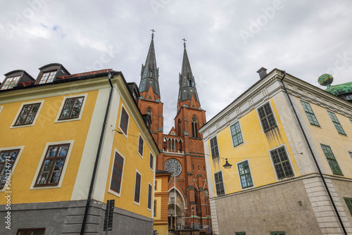 Beautiful view up on two church towers between tops of old yellow buildings. Sweden. 