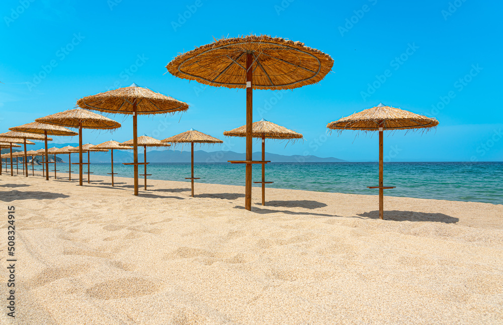 empty beach with wooden sun umbrellas on the mediterranean sea