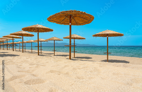 empty beach with wooden sun umbrellas on the mediterranean sea
