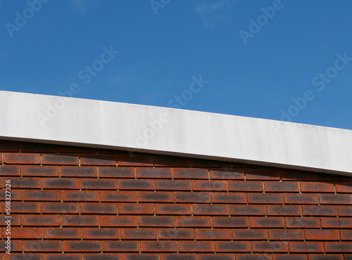 Deep blue sky above brick wall with white border with copy space