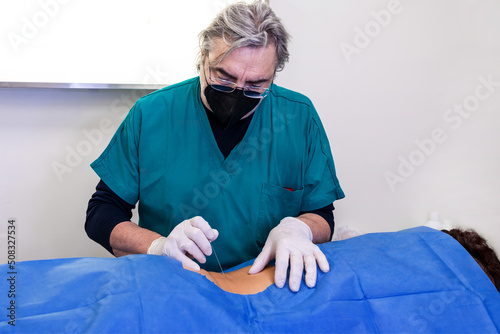 Infiltration for lumbar hernia. Ultrasound-guided infiltrative therapy for back pain treatment. Doctor practices the infiltration of drugs to the patient in the area affected. photo