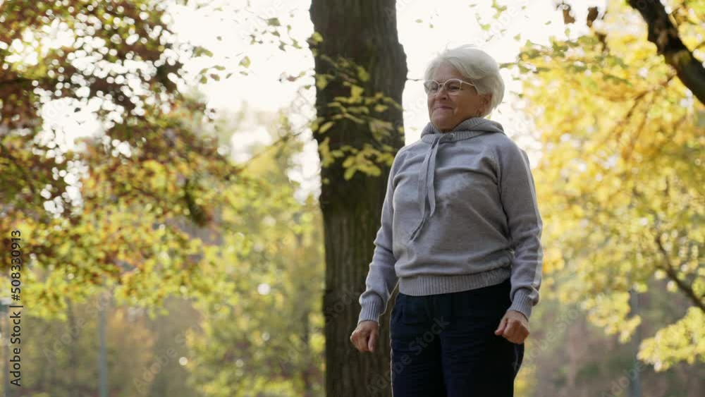 Middle aged Caucasian woman running on the spot, gymnastics in park medium shot copy space . High quality 4k footage Middle aged Caucasian woman running on the spot, gymnastics in park medium shot copy space . High quality 4k footage