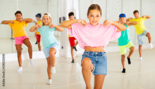 Group of children are learning dance moves in a modern studio