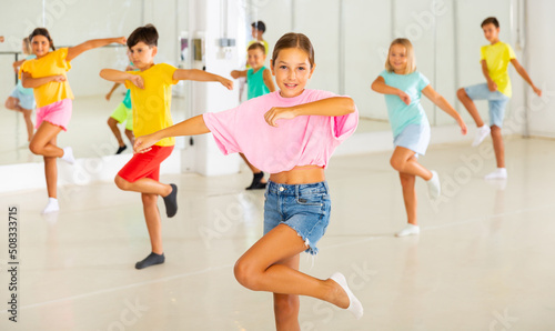 Active children dancing modern dances in a choreographic studio