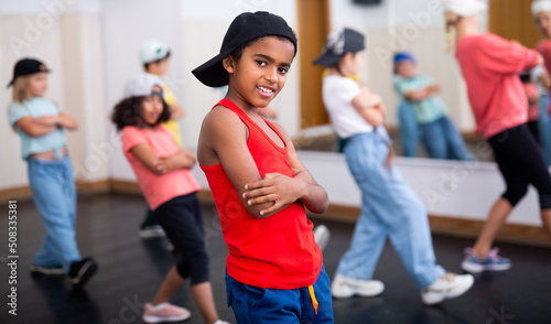 Little Afro boy hip hop dancer exercising with friends at dance class