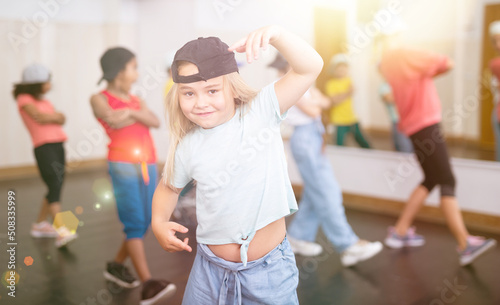 Cute tween girl hip hop dancer posing during workout in group dance class for children.. © JackF