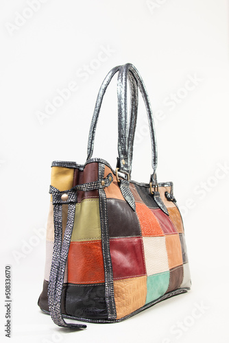 Patched multicolor female hand bag with two handles on white background isolated