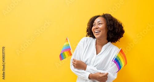 Leinwand Poster Portrait of African woman waving LGBTQ rainbow flag for coming out of the closet