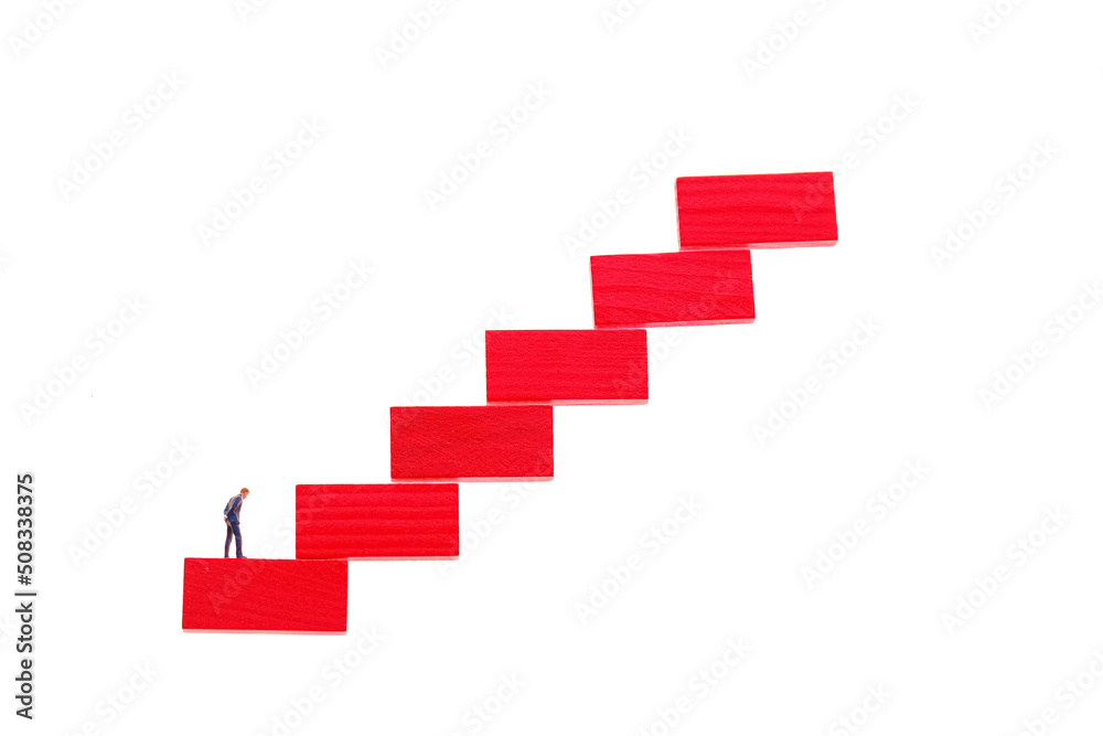 Career ladder concept.Career growth concept. Figurine of a businessman on a red step ladder isolated on a white background Career ladder concept.Career growth concept. Figurine of a businessman on a red step ladder isolated on a white background