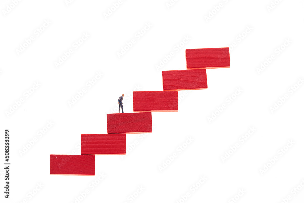 Career.Career ladder concept.Career growth concept. Figurine of a businessman on a red step ladder Career.Career ladder concept.Career growth concept. Figurine of a businessman on a red step ladder