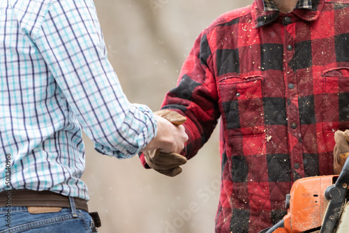 Φωτογραφία White collar man in formal attire shaking hand of blue collar working outdoors m