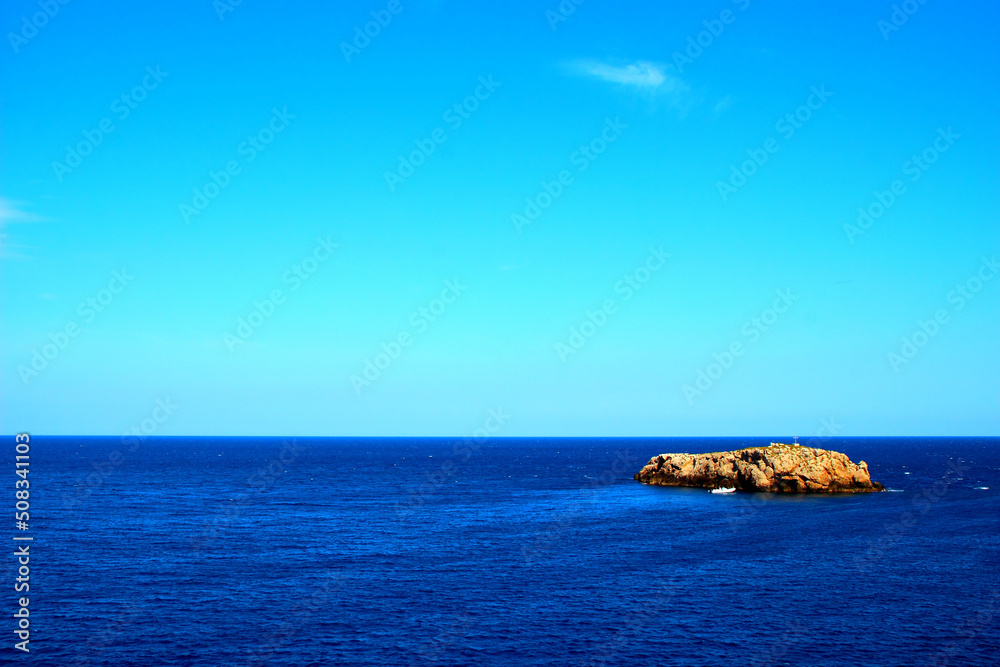 Beautiful panorama in Polignano a Mare with the deep blue Adriatic sea and a massive rock on the right under the azure sky on a sunny summer day